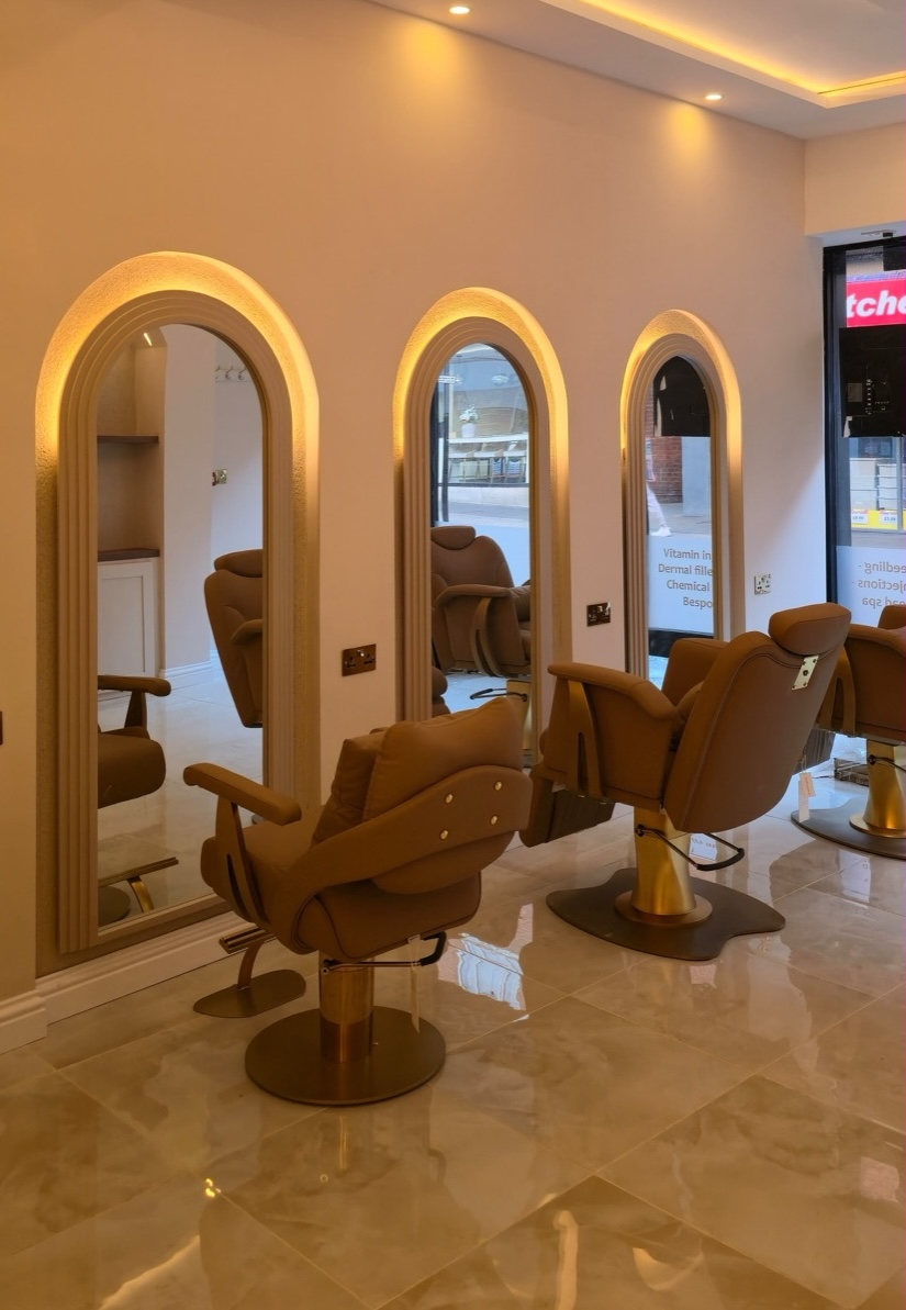 Arched mirror styling stations with tan leather chairs inside the Gazals clinic